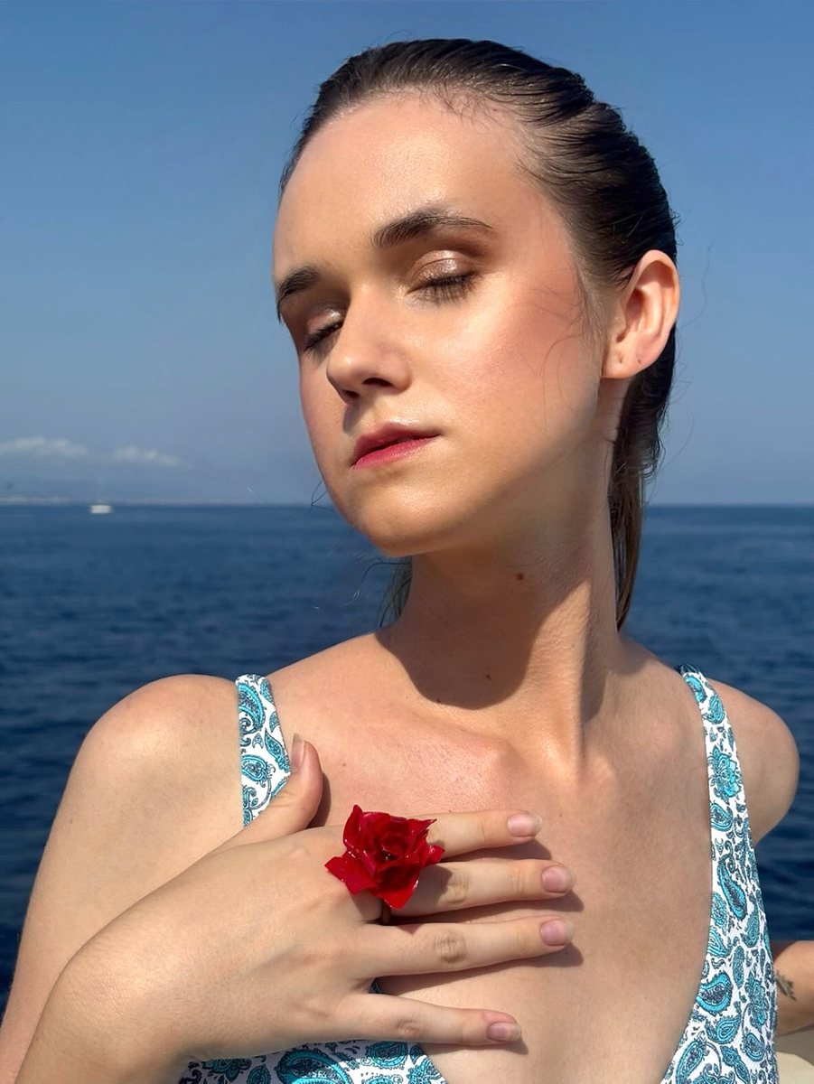 Beauty portrait by the sea with a red rose ring